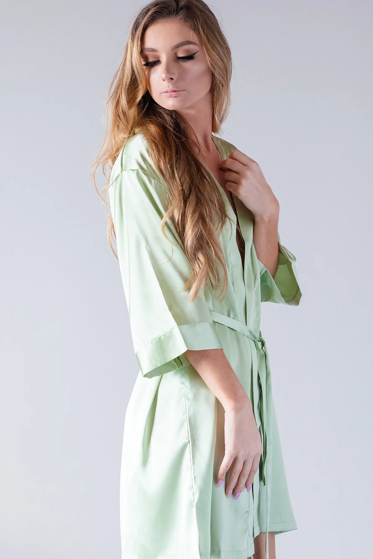 Side view of woman modeling personalized sage green satin kimono bridesmaid robe with tie waist — custom bridal party robe