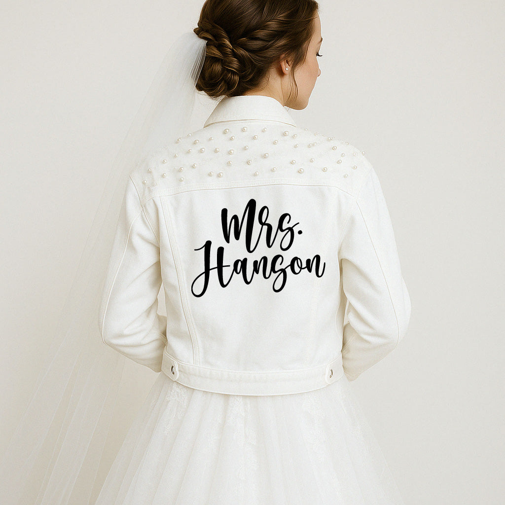 Woman wearing a white jacket with 'Mrs. Hanson' text on the back against a plain background
