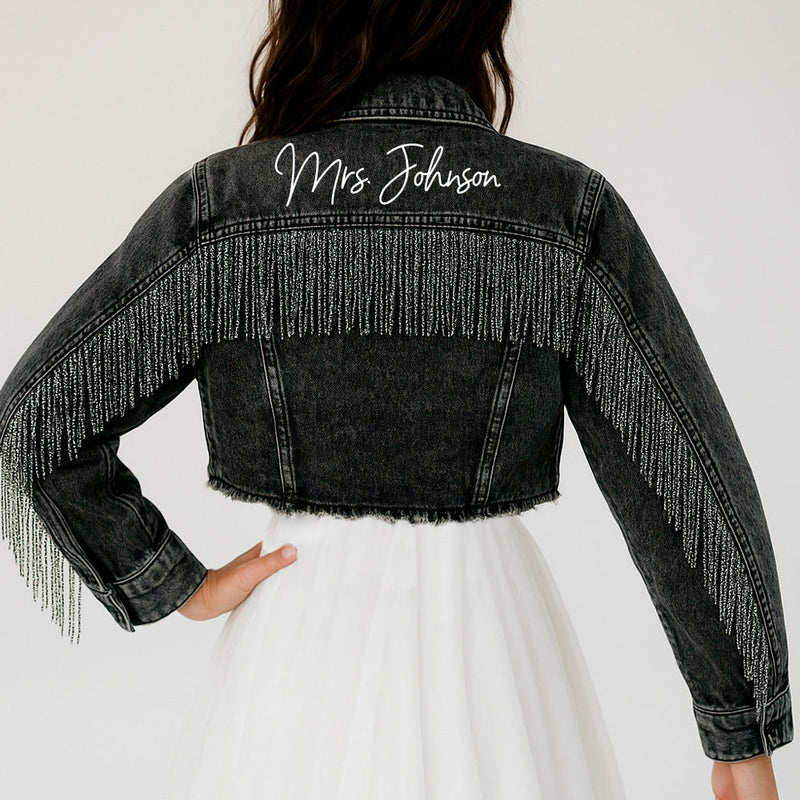 a woman wearing a jean jacket with fringes on it