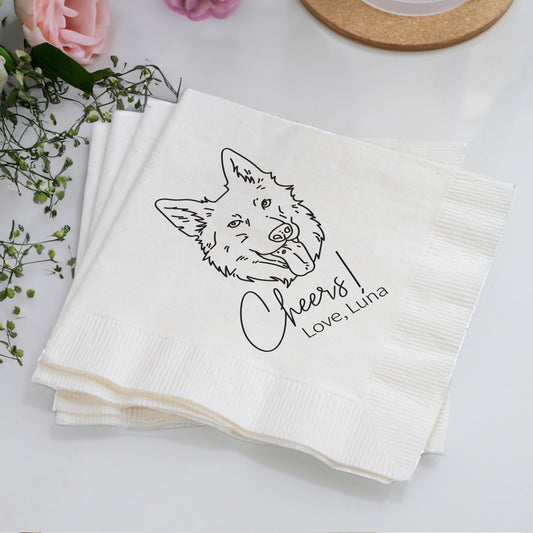Stack of white napkins with a fox illustration and text on a light surface with flowers and a coaster.