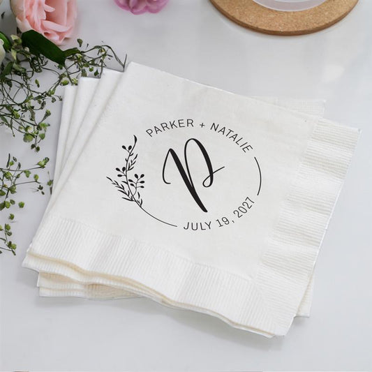 White napkins with personalized design on a light surface with flowers.