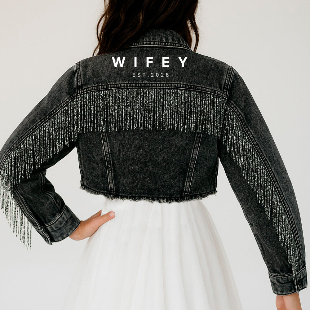 a woman wearing a black jacket with fringes on it