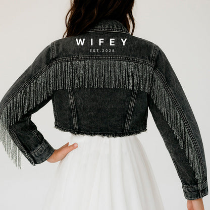 a woman wearing a black jacket with fringes on it