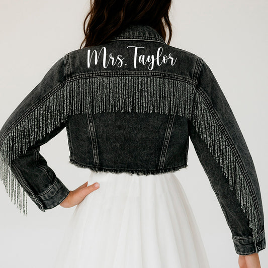 a woman wearing a black jean jacket with fringes