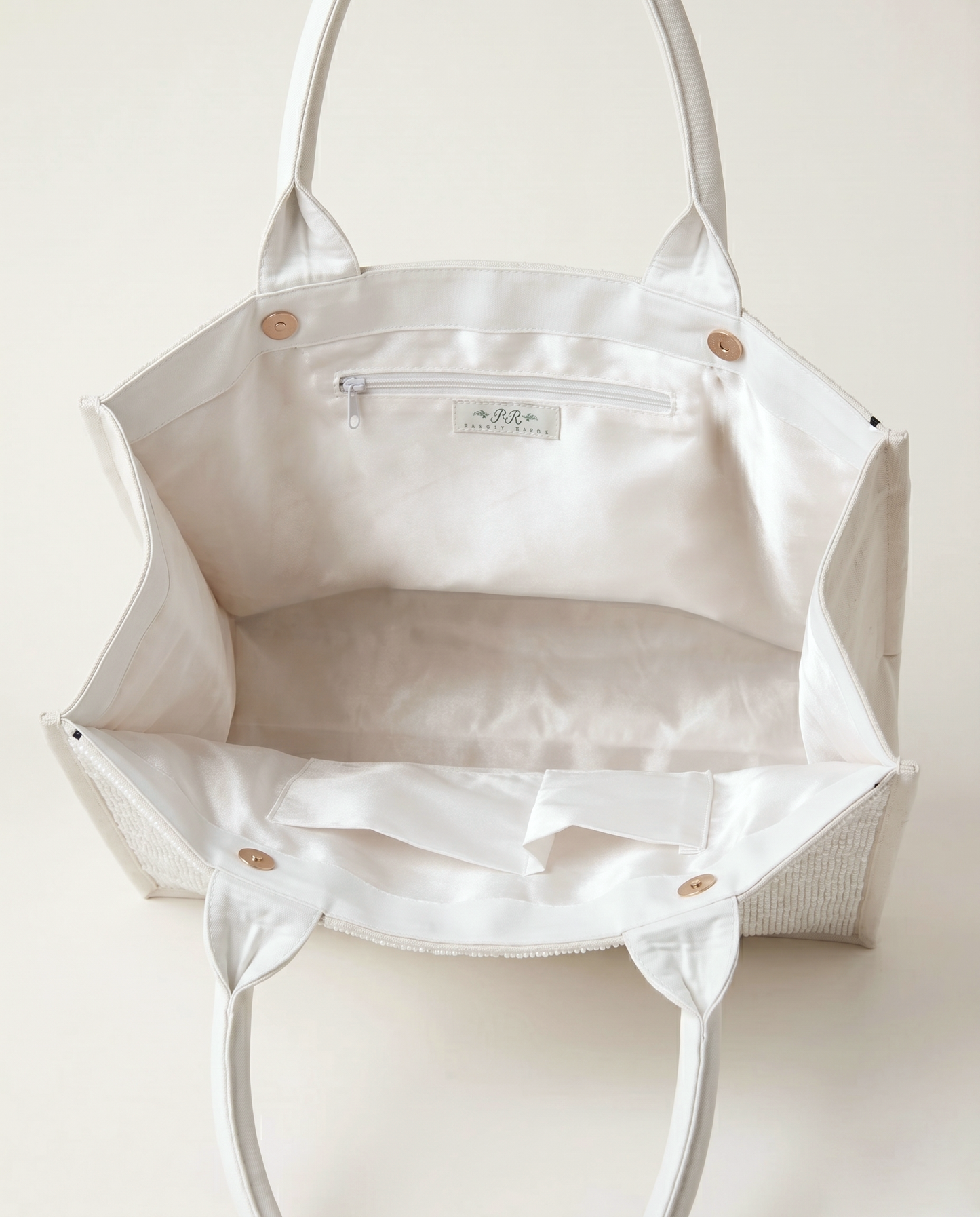 A white tote bag with a zipper and handles, open to reveal the interior.