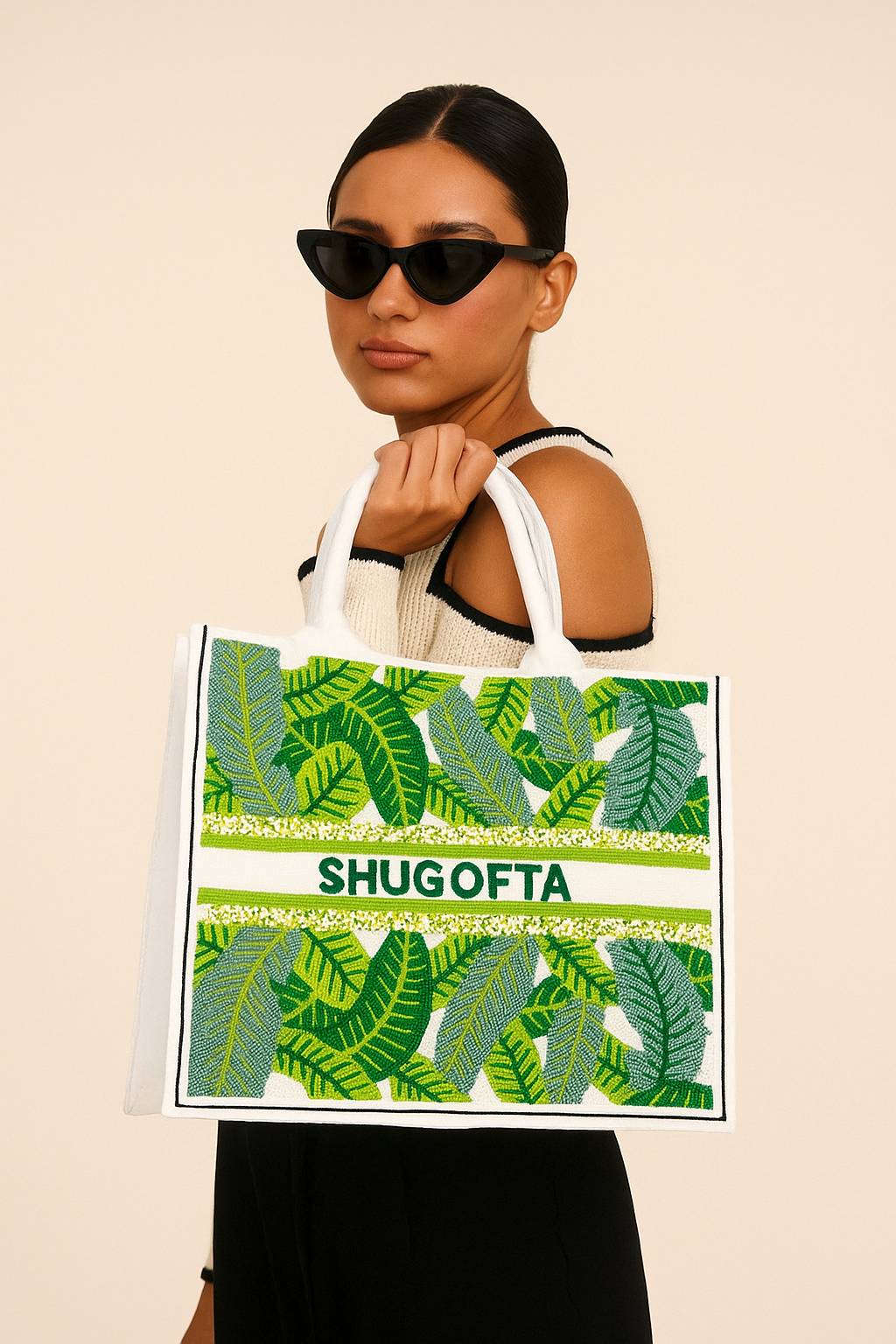 a woman holding a shopping bag with a picture of leaves on it