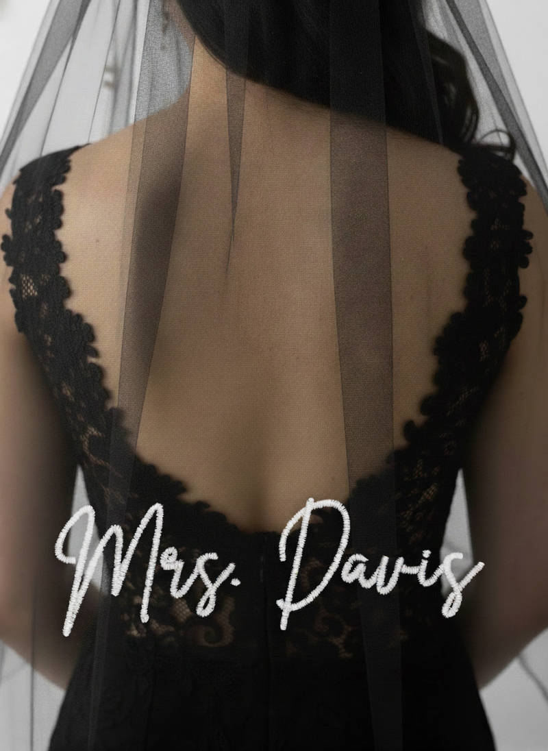the back of a person wearing a black lace dress with a veil, and the name "Mrs. Davis" written on the back of the dress.