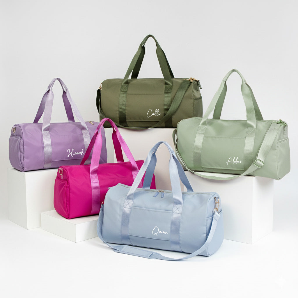 a collection of six colorful duffel bags, each with a unique color and design, arranged on a white background.
