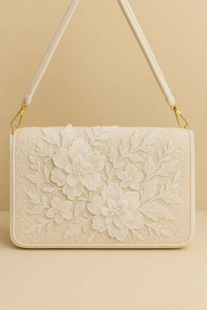A white, floral-patterned handbag with a gold-colored strap and handle.