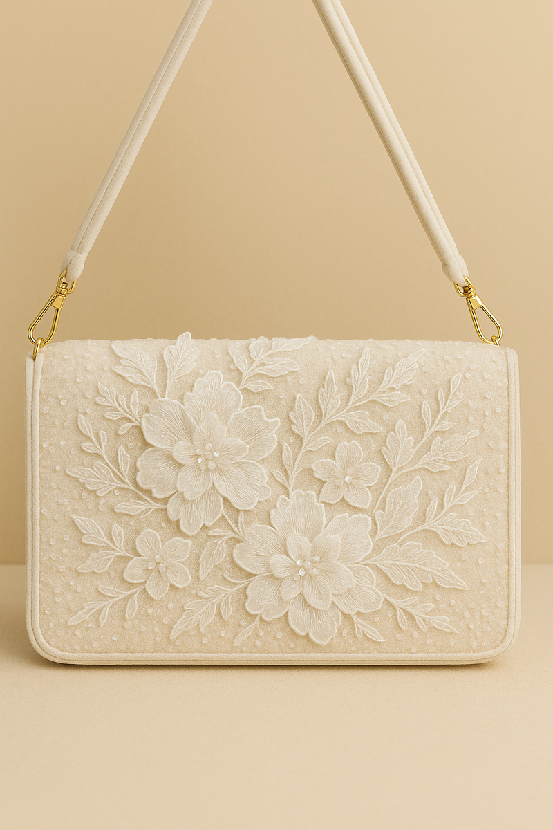 A white, floral-patterned handbag with a gold-colored strap and handle.