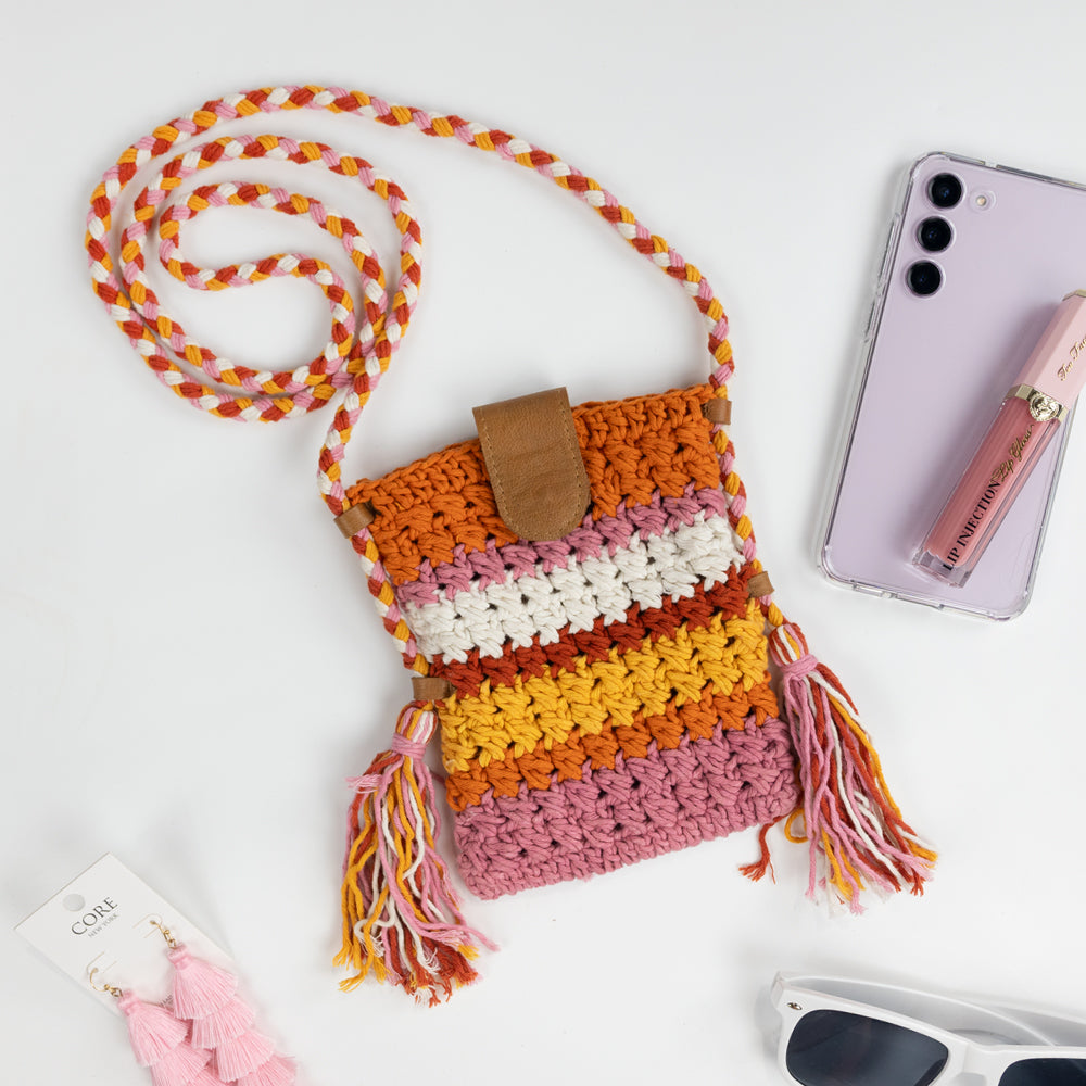 Boho-inspired Small Crossbody Cell Phone Purse, intricately crocheted in a stylish design. Measuring 5.25 in x 6.5 in x.5 in, it comfortably fits standard-sized phones and small essentials like a thin wallet or lip gloss. The 42 in strap allows it to drape effortlessly as a crossbody, secured with a sturdy leather magnetic snap closure. A chic and practical accessory, ideal for brides looking for a blend of function and fashion.