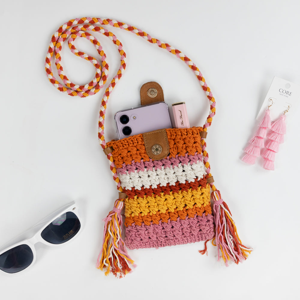 Boho-inspired Small Crossbody Cell Phone Purse, intricately crocheted in a stylish design. Measuring 5.25 in x 6.5 in x.5 in, it comfortably fits standard-sized phones and small essentials like a thin wallet or lip gloss. The 42 in strap allows it to drape effortlessly as a crossbody, secured with a sturdy leather magnetic snap closure. A chic and practical accessory, ideal for brides looking for a blend of function and fashion.