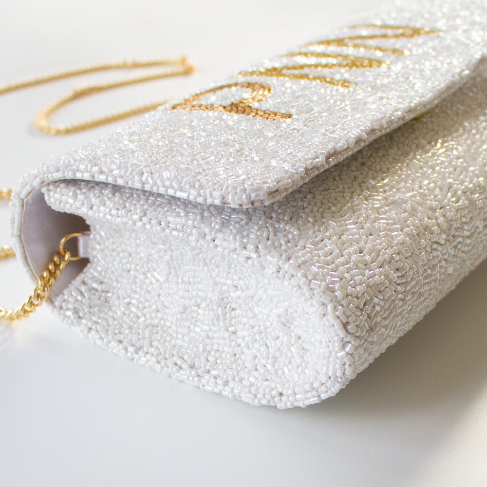 Elegant bridal clutch adorned with intricate beadwork, perfect accessory for a wedding ensemble. Color White