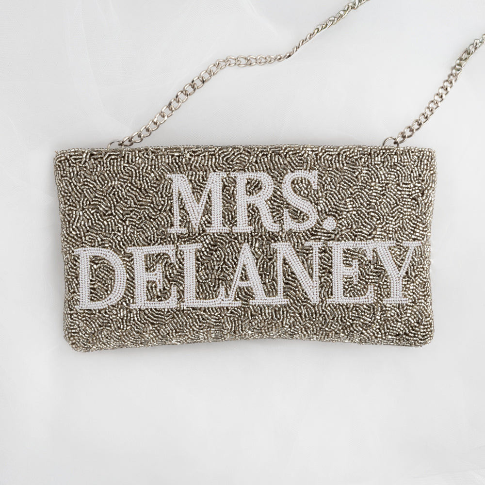 A handbag with the name "Mrs. Delaney" embroidered on it.