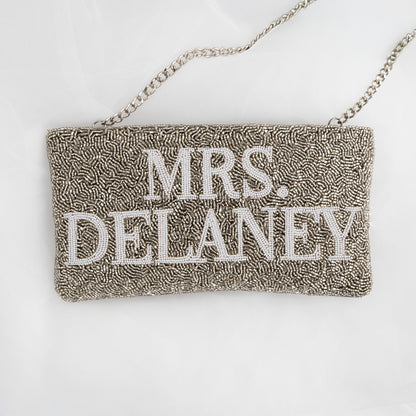 A handbag with the name "Mrs. Delaney" embroidered on it.