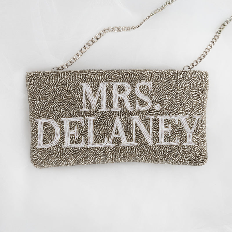 A handbag with the name "Mrs. Delaney" embroidered on it.