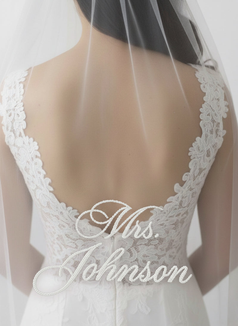 the back of a bride's dress with the name "Mrs. Johnson" embroidered on it.