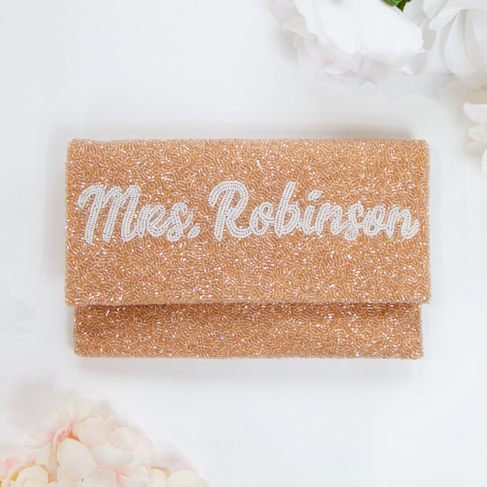 Chic Bridal Clutch: Personalized Seed Bead Clutch Purse for Brides, measuring 9 1/2″ wide x 5″ tall. Handcrafted with a velvet interior, this clutch offers both style and functionality for brides. Every handmade clutch is uniquely designed, making it an exquisite accessory for the special day.
