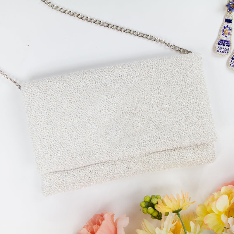 Title/bridal Clutch "Elegant white beaded bridal clutch, handmade to perfection, sized at 10.5 x 7 x 1 inches. This durable canvas bridal clutch with magnetic snap closure offers a stylish and practical solution for the wedding day, ensuring each bride has a unique accessory for her special occasion."