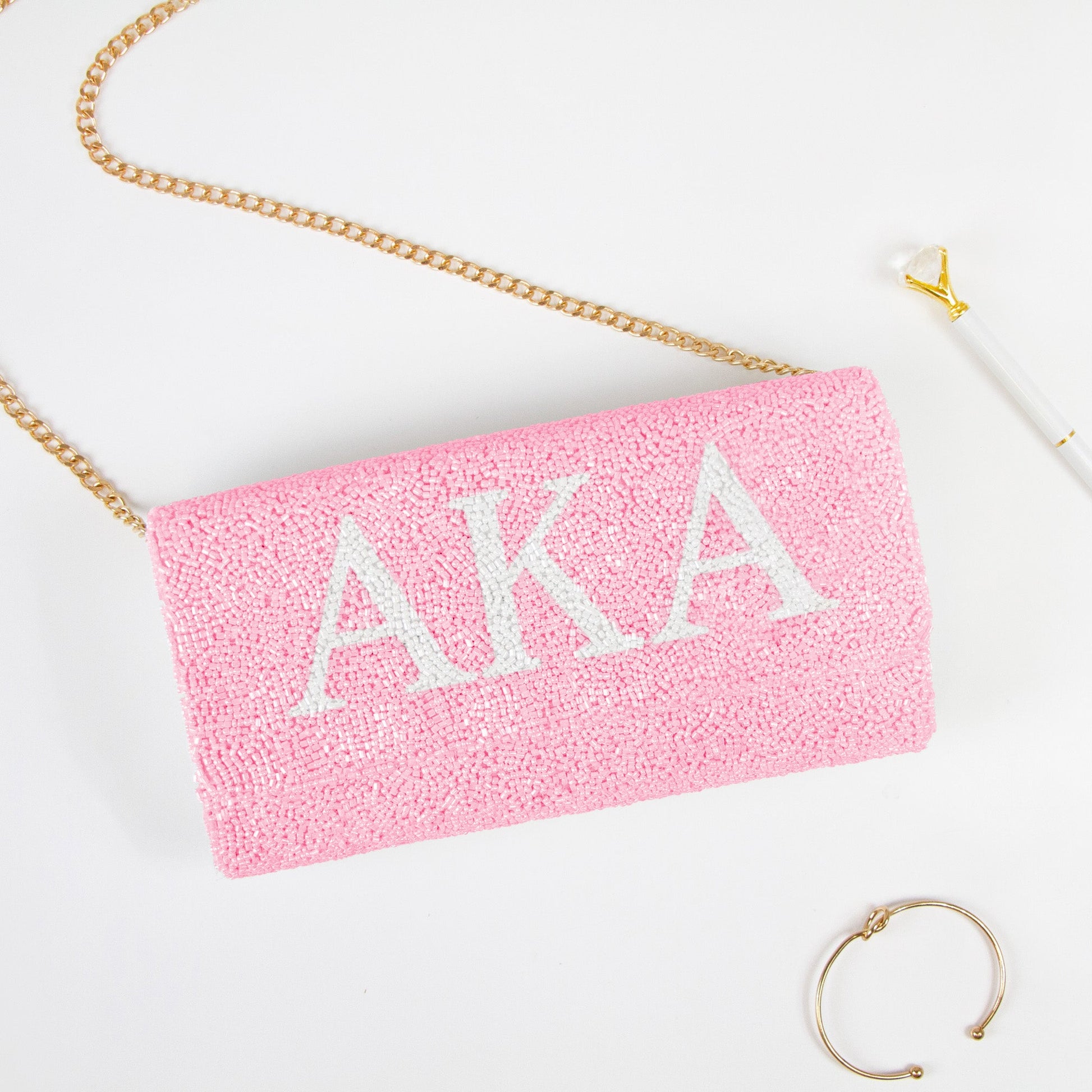 Elegant Personality Sorority Beaded Clutch Bag showcasing intricate beading patterns. Handcrafted to perfection, this clutch offers both style and function for weddings and special events. Features a customizable date inside, and an option for a gold or silver chain. Measuring at 9.5in x 5in x 3in, it's spacious enough for essentials while retaining a sophisticated silhouette. Each clutch celebrates unique craftsmanship, ensuring every piece is a one-of-a-kind accessory."