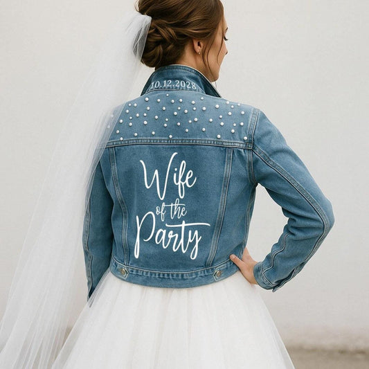 Denim jacket with 'Wife of the Party' text and date, worn by a person in a white dress.