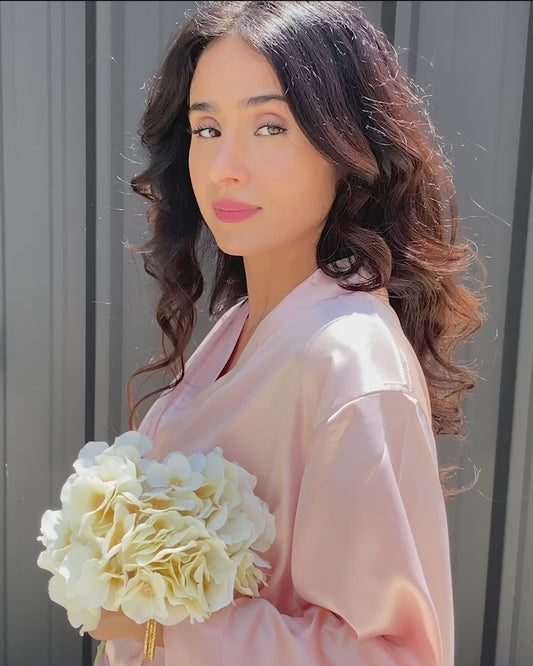 Woman wearing personalized white satin bridesmaid robe holding bridal bouquet — custom getting-ready robe for weddings by PrettyRobes