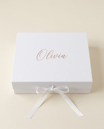 Personalized proposal box: white magnetic-flap gift box, white satin bow, her name printed on the lid (render, placeholder until photographed)