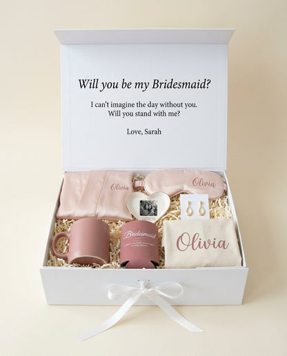 Say Yes bridesmaid box open: letter printed inside the lid, satin robe, mug, photo trinket tray, eye mask with her name, bridesmaid earrings, Bridesmaid can cooler, canvas tote with her name (render)