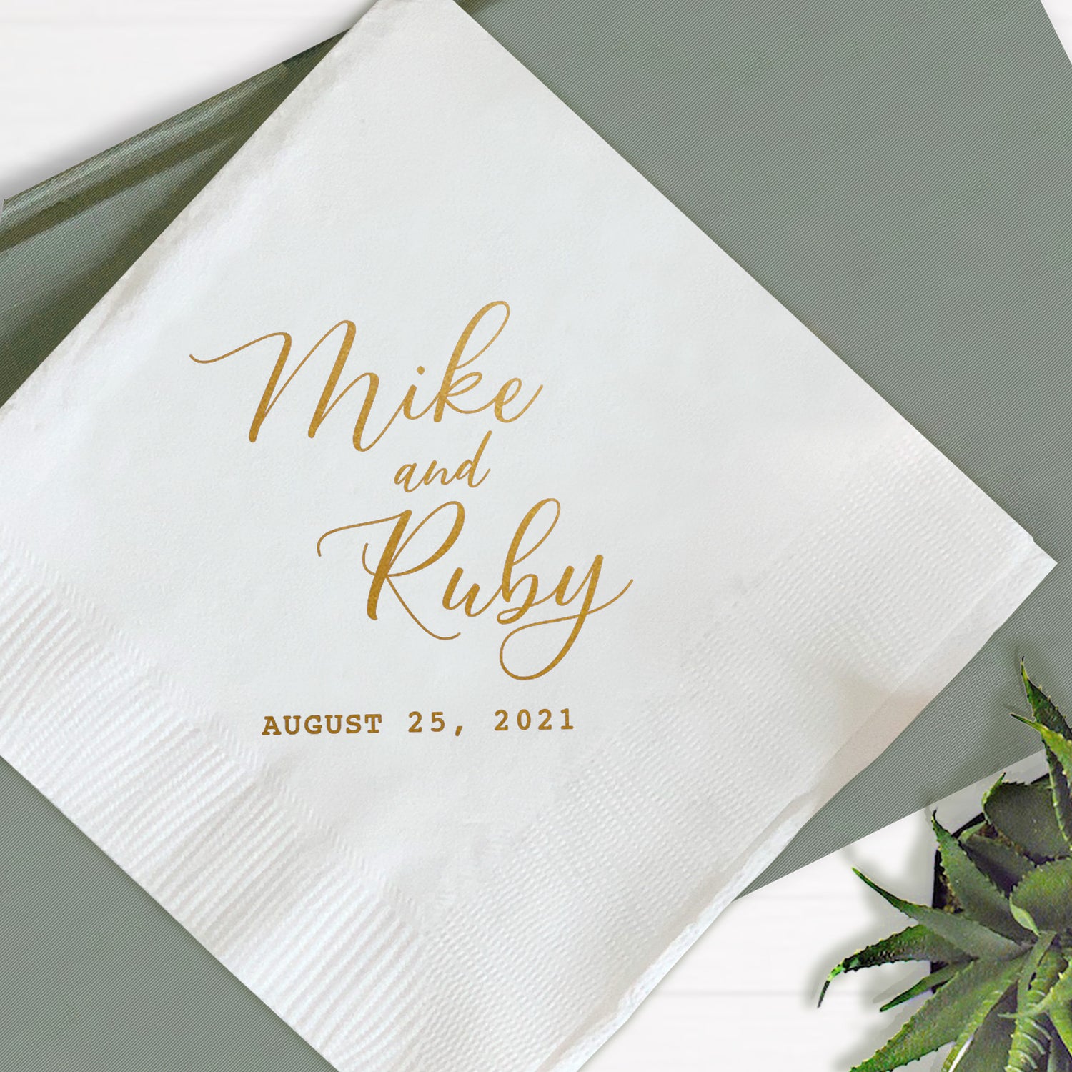 A personalized wedding napkin with the names 'Mike and Ruby' printed on it, along with a date 'Aug 25, 2021'.