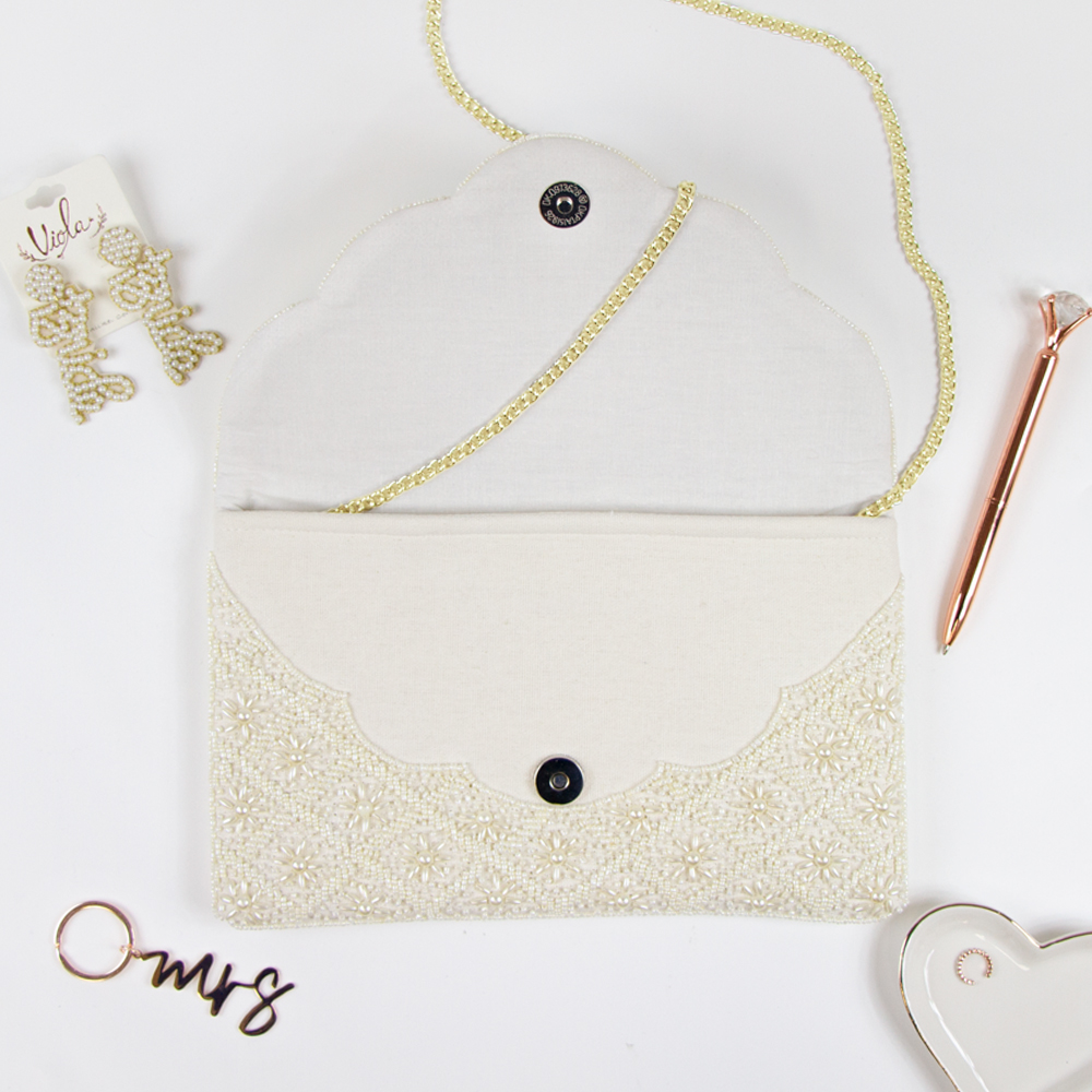 Elegant Bridal Clutch: Plain White Scallop Pearl Clutch Bag measuring 6.5 x 10 x 1in. Crafted from durable canvas with a magnetic snap closure and detailed with intricate gold beading. Each handcrafted clutch offers a unique design, perfect for brides seeking an exceptional accessory for their special day.