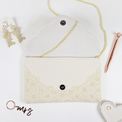 Elegant Bridal Clutch: Plain White Scallop Pearl Clutch Bag measuring 6.5 x 10 x 1in. Crafted from durable canvas with a magnetic snap closure and detailed with intricate gold beading. Each handcrafted clutch offers a unique design, perfect for brides seeking an exceptional accessory for their special day.