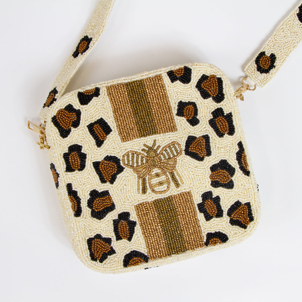 Alt Text: "Trendy Leopard Print Beaded Box Bag, blending a vibrant leopard print with playful pink lightning bolt accents on the crossbody strap. This 8x8x2-inch handcrafted purse features a peach canvas back, enhanced by chic gold details. The detachable 46-inch beaded strap offers versatility for any occasion. Each bag is uniquely crafted, ensuring a distinct and exclusive accessory to complement both day and night looks