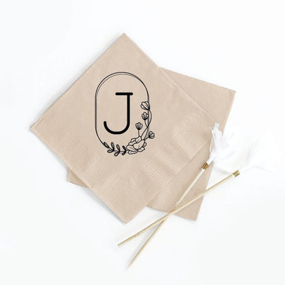 Napkins with a floral monogram with the letter J in the middle.